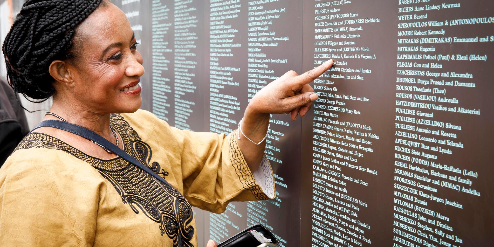 Portrait of female in front of the National Monument to Migration wall