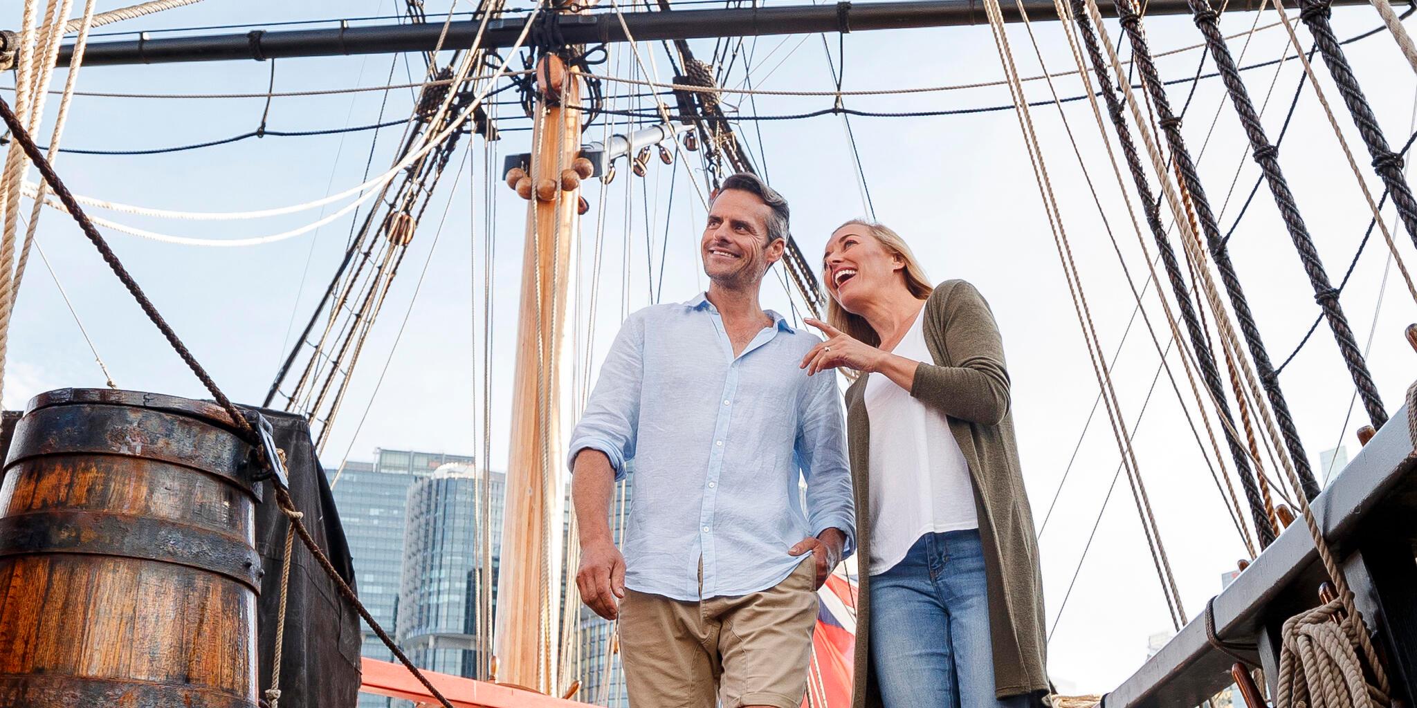 A couple standing on the deck of replica wooden tall ship Endeavour