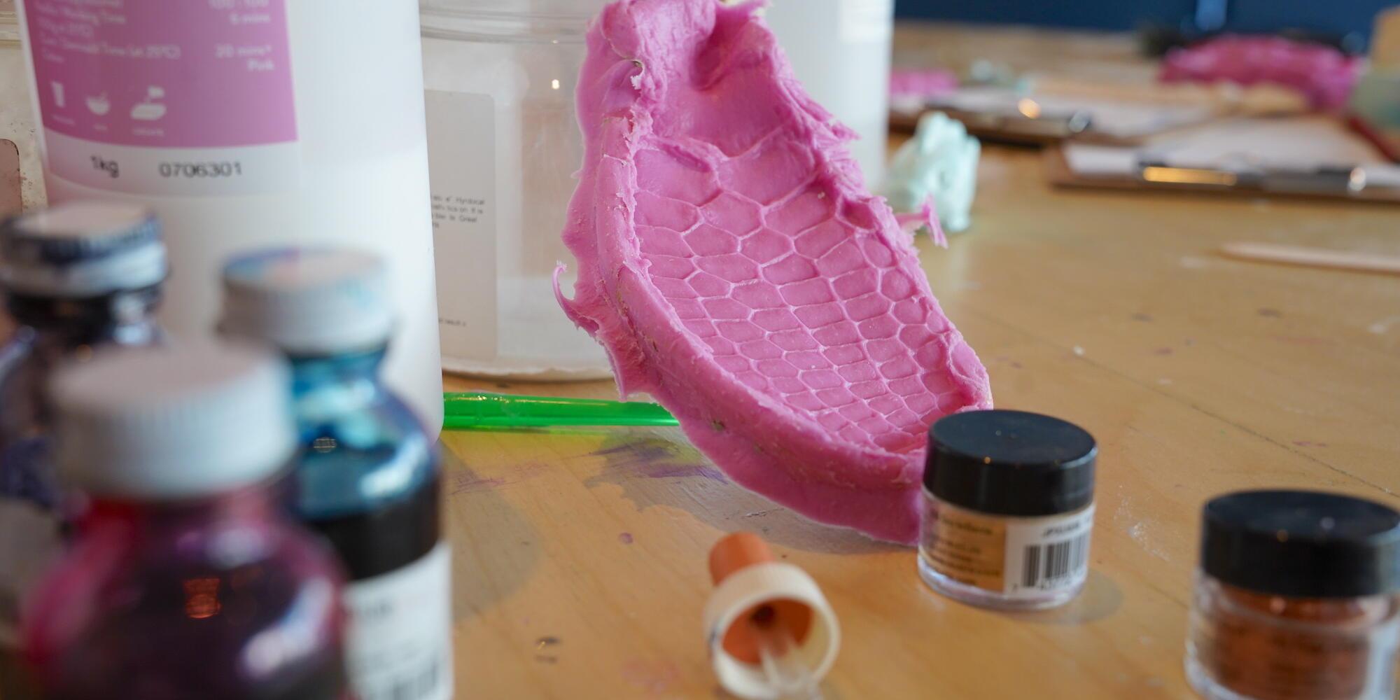 A table with a pink silicone mould and other craft materials