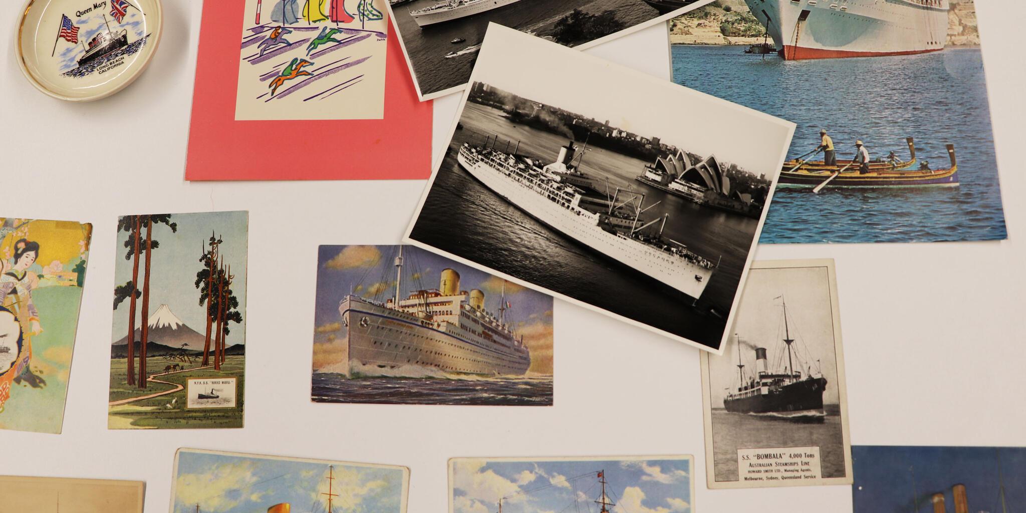 Selection of photos, postcards and illustrations on a white table.