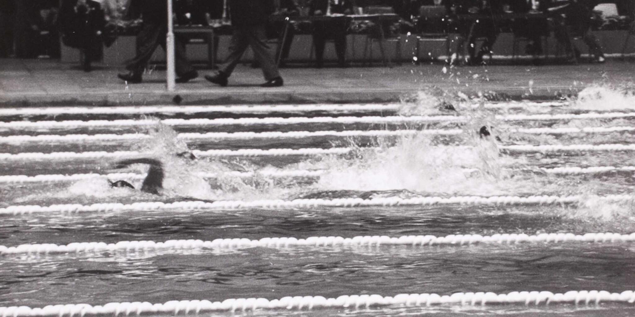 Black and white photo of a person swimming in a pool