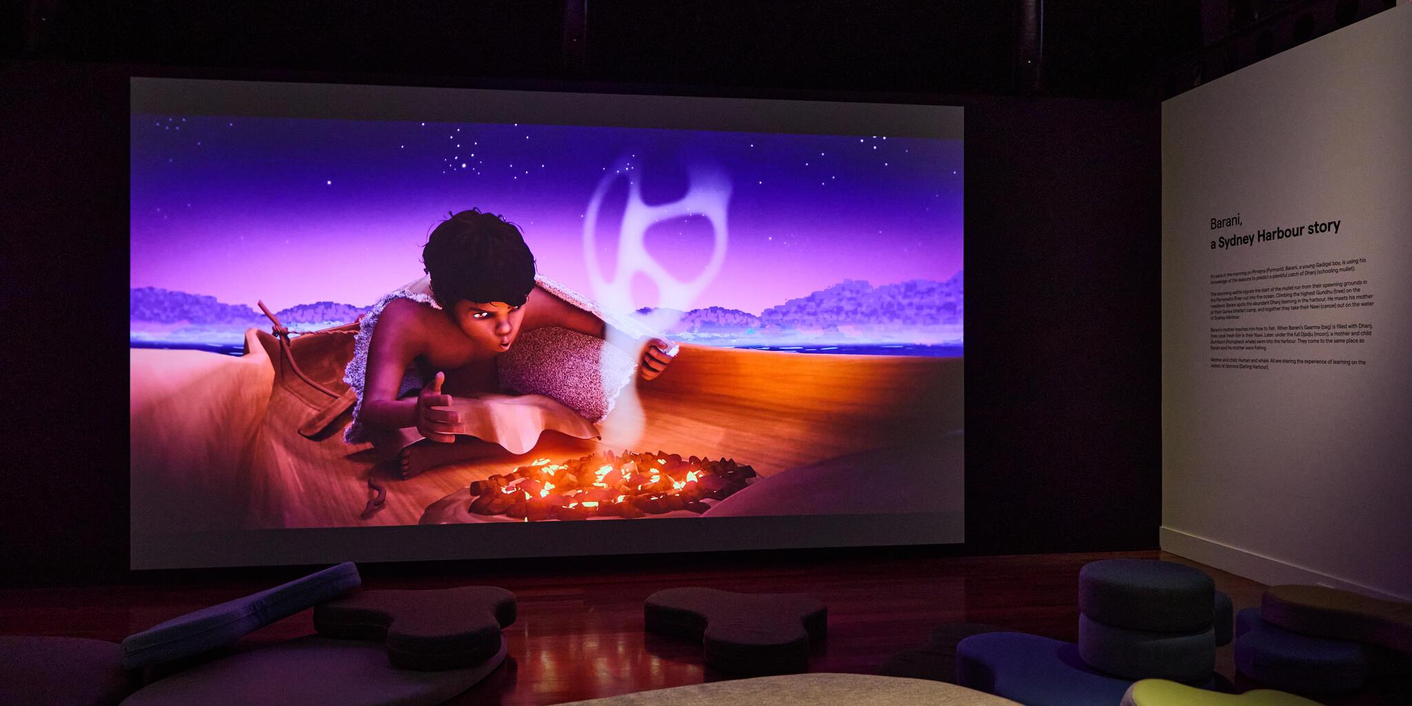 Photo of video work on a screen, showing an animation of an aborigional boy lighting a small fire