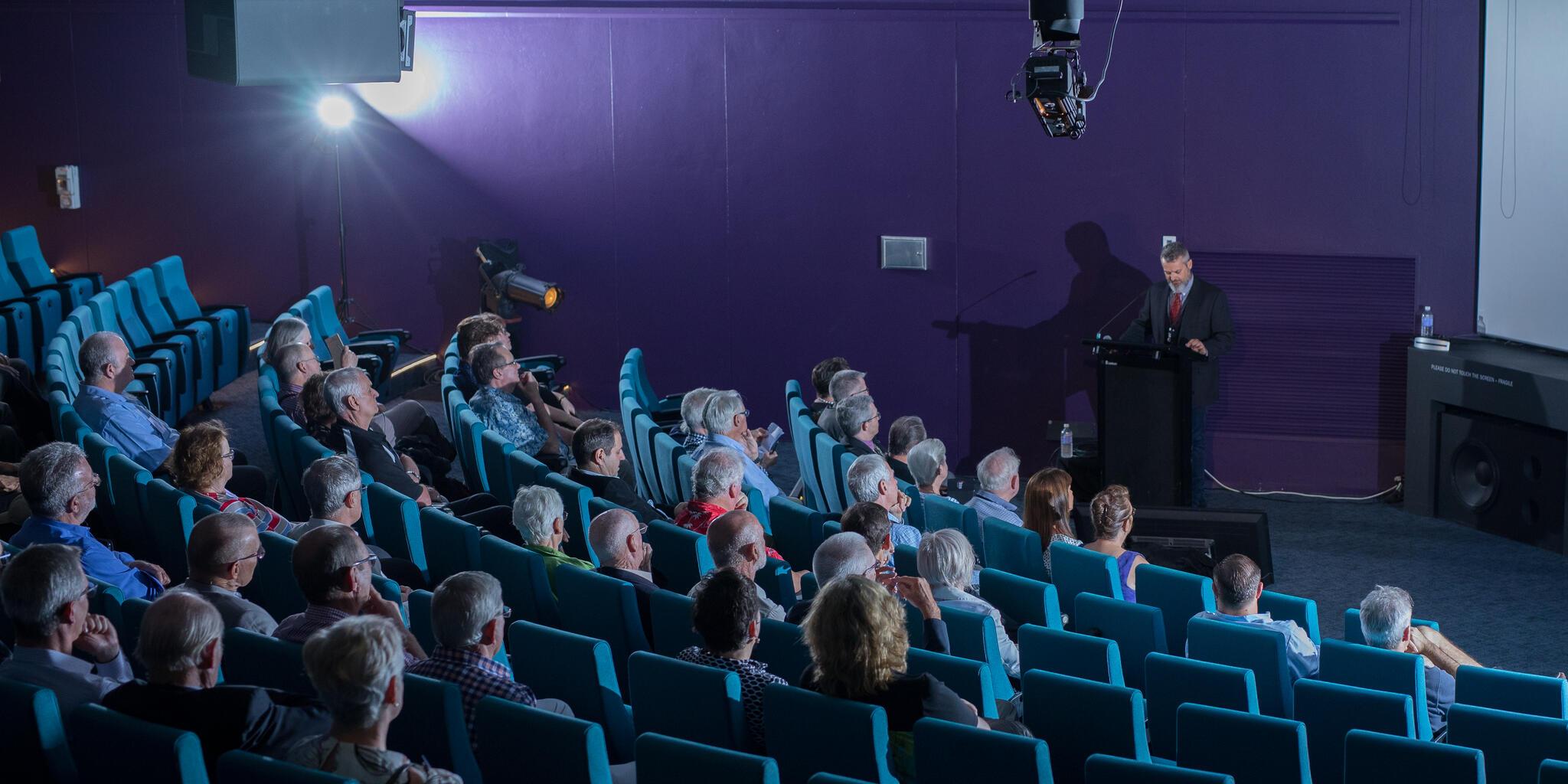 photo of a large audience in the museum theatre