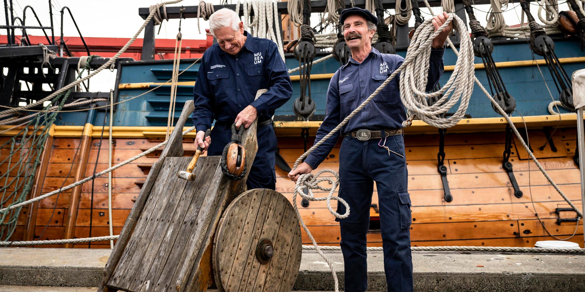 2 Fleet Services volunteers, standing in front of the ENDEAVOUR.