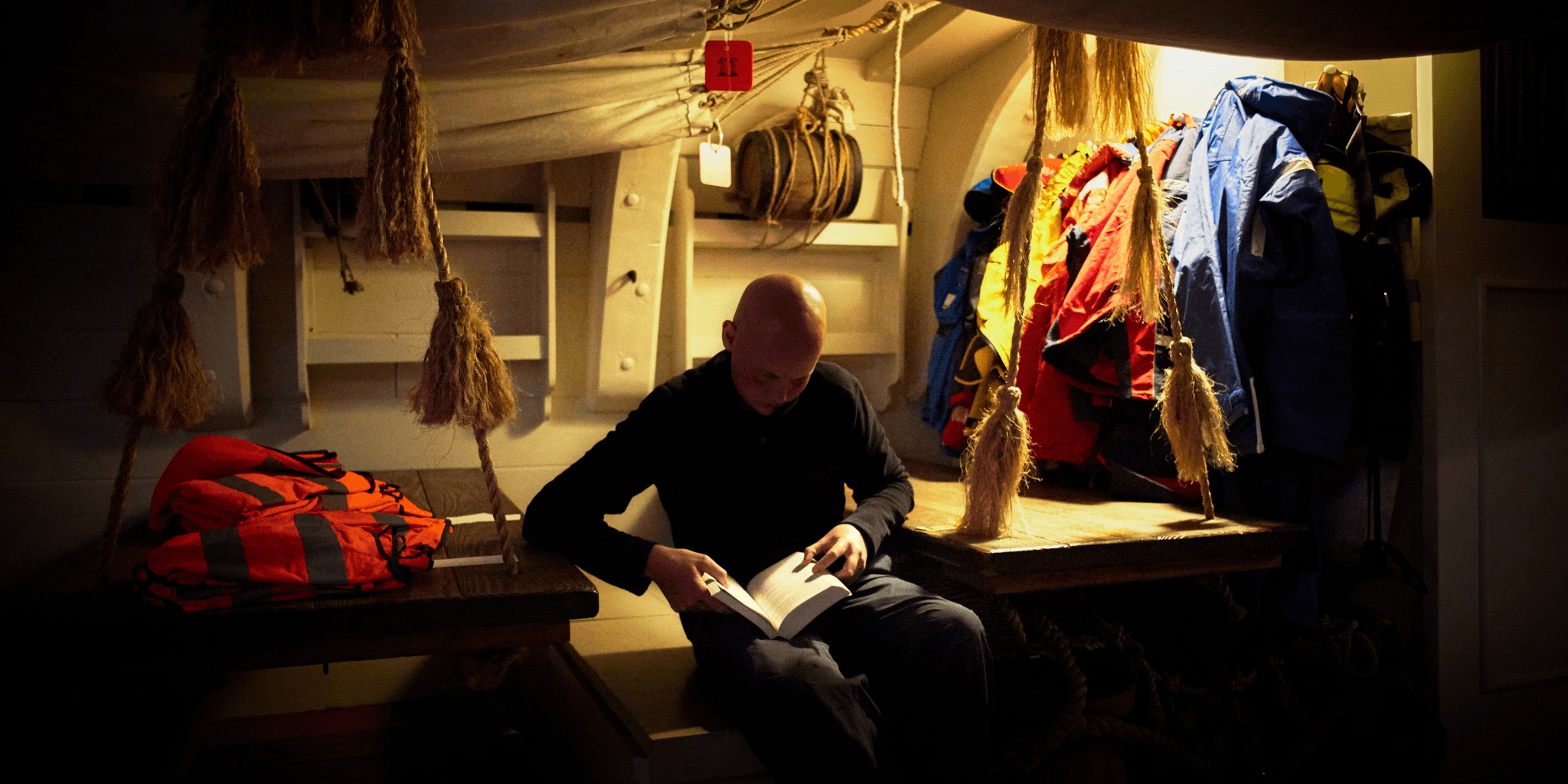  Below deck. Man reading. 