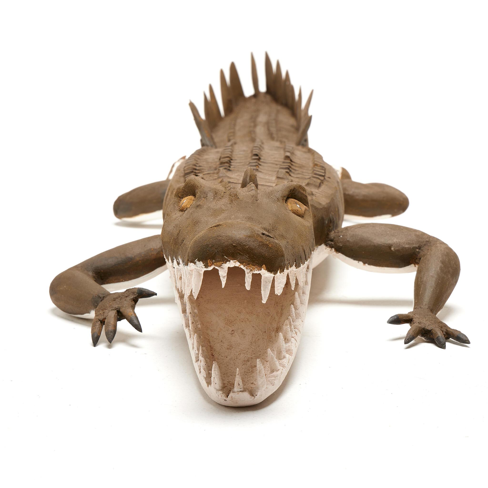 A wooden crocodile viewed from the front.