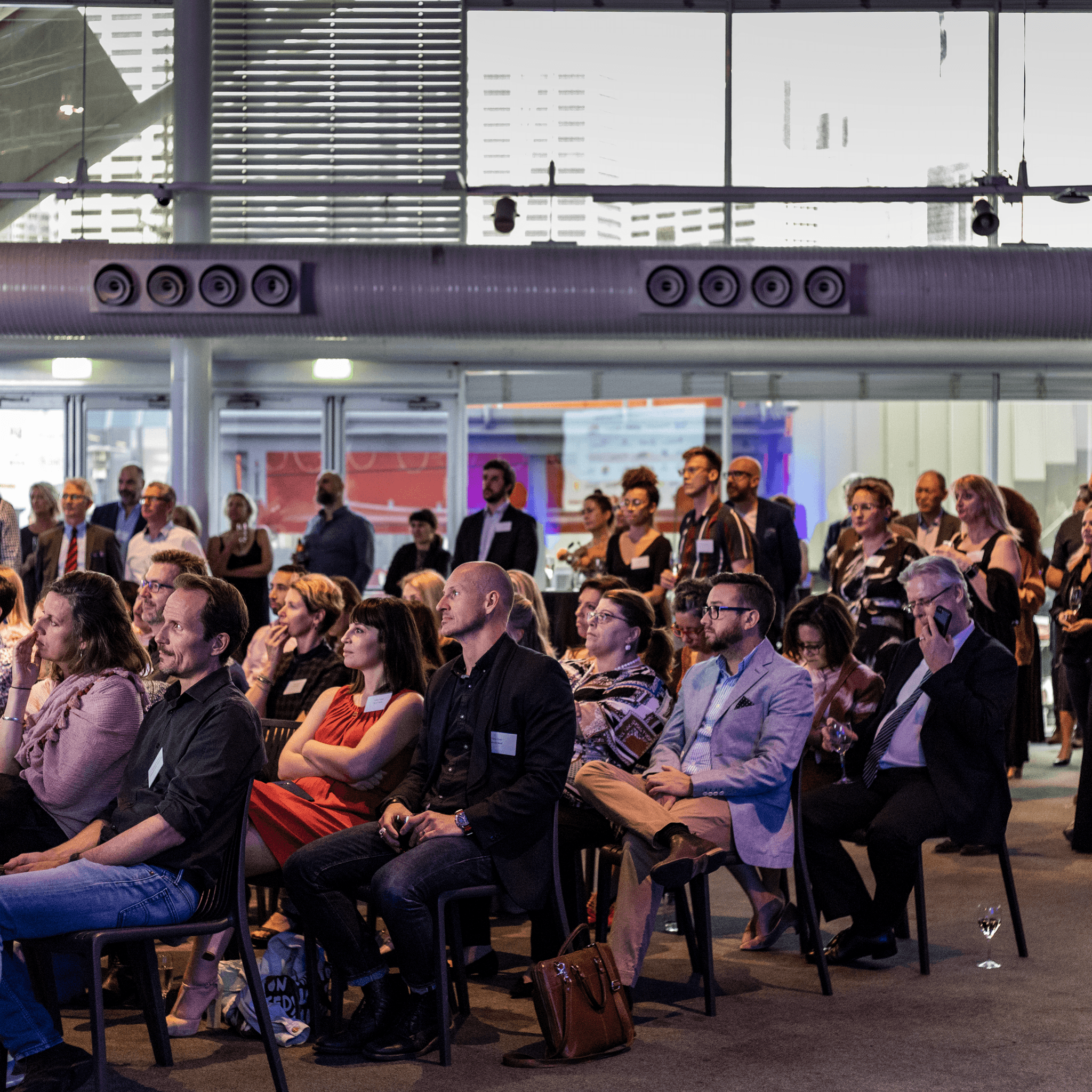  Audience of event guests listening to event speeches.