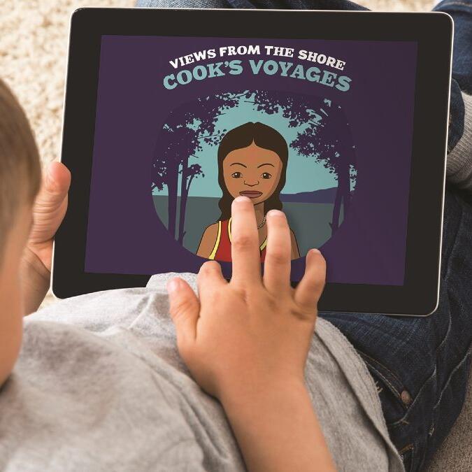 A boy holds an ipad showing a purple screen saying "Cook's Voyages" and an image of an aborigional girl. 