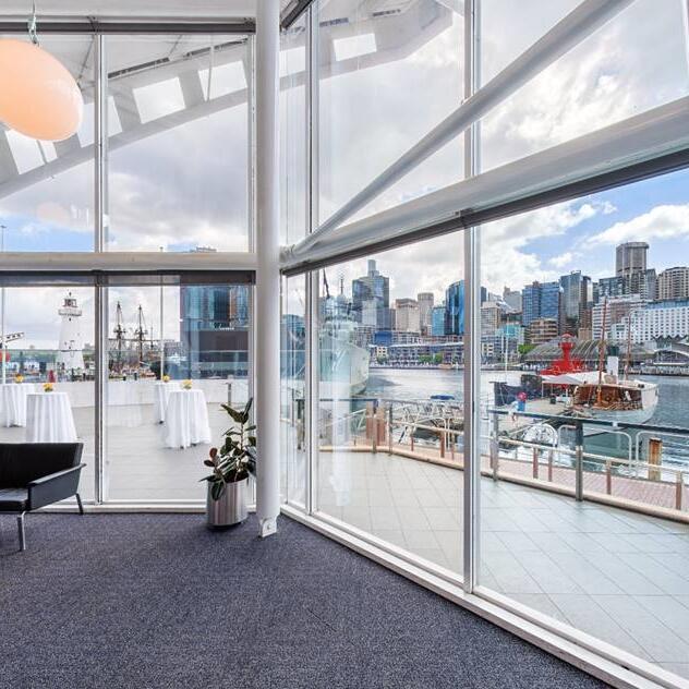 photo showing a wall of windows with a balcony and the harbour beyond. 