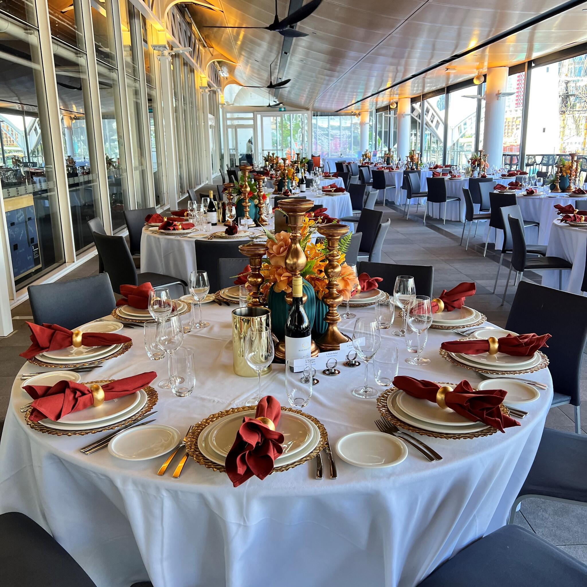 photo of round table with white tablecloth and decorations on a covered terrace