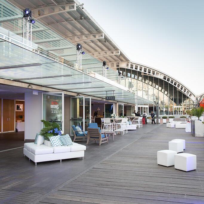 photo of museum boardwalk with glass wall open to interior event space.