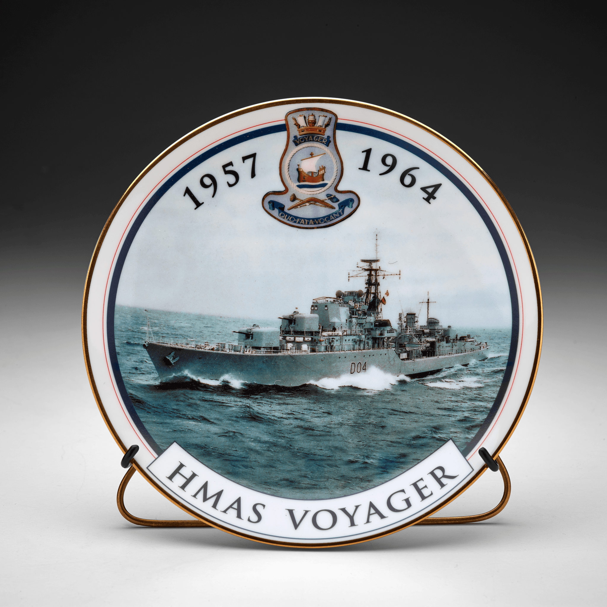 Gold rimmed plate with colour image of HMAS VOYAGER, Daring class destroyer at sea. Printed at the top is "1957 [VOYAGER Logo] 1999". Printed at the bottom is: "HMAS VOYAGER". Printed on the back of the plate is: "In commemoration / of the 35th anniversary / of the loss of / HMAS VOYAGER / 1964 - 1999 / plate no: 350 / designed and decorated in Australia - blank made in Japan".