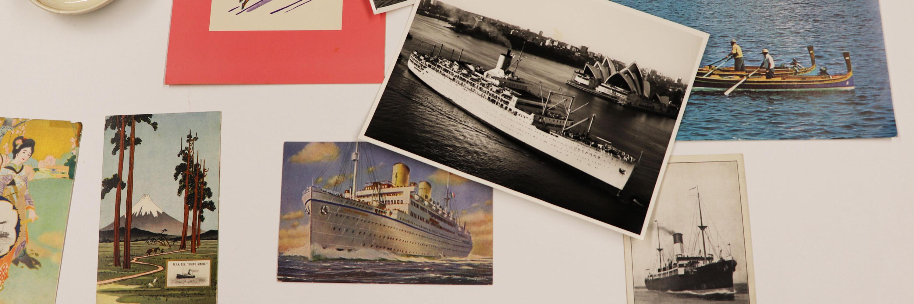 Selection of photos, postcards and illustrations on a white table.