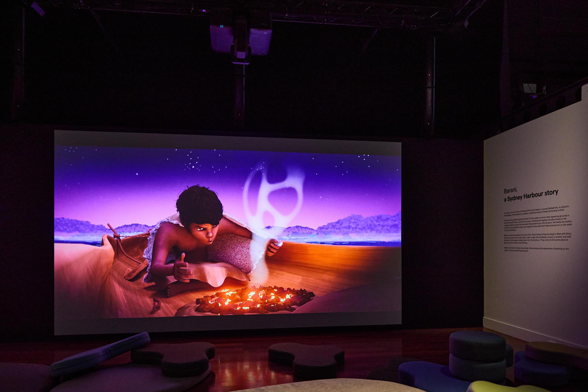 Photo of video work on a screen, showing an animation of an aborigional boy lighting a small fire