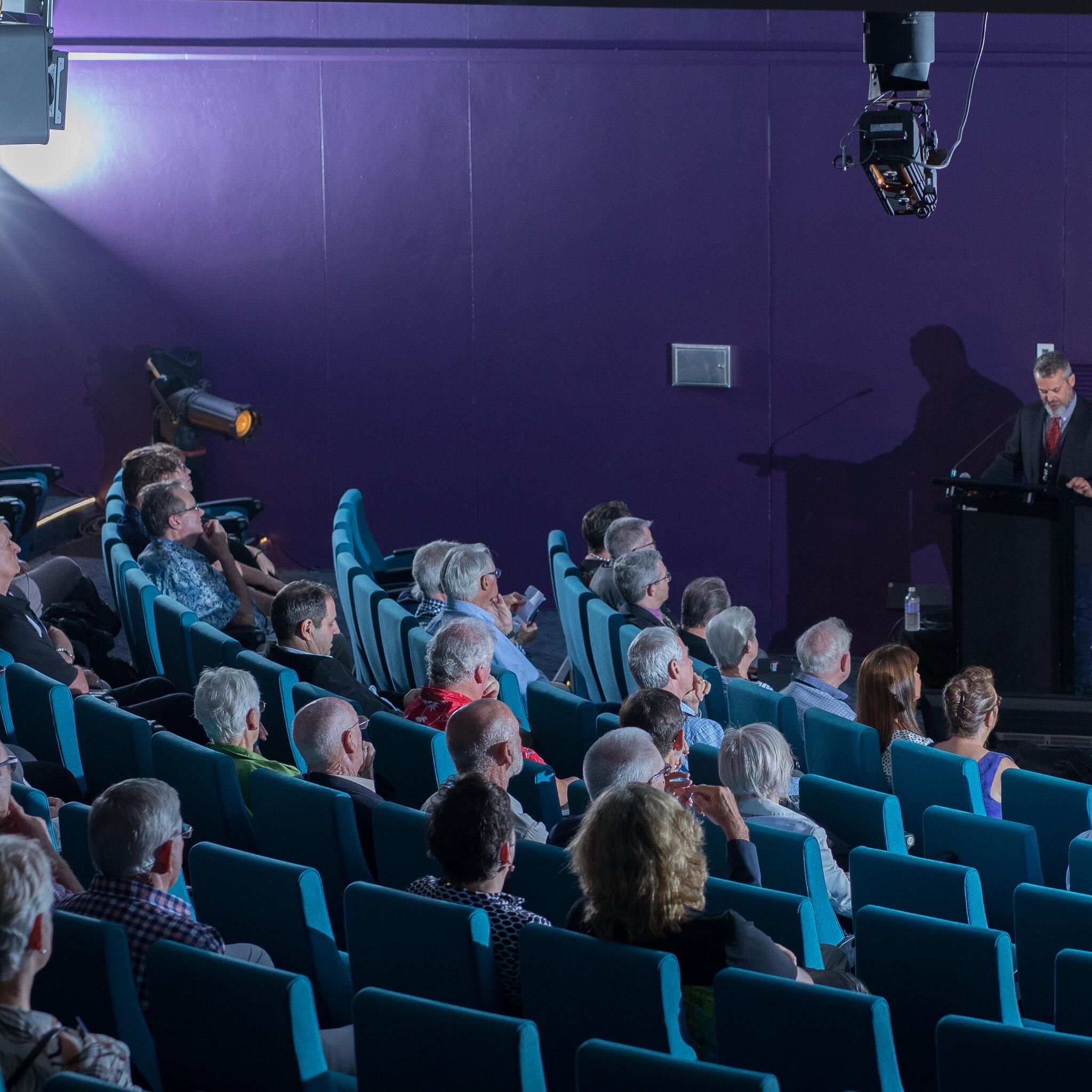 photo of a large audience in the museum theatre